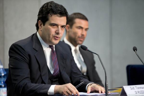 FILE -- In this April 28, 2016 file photo, Tommaso Di Ruzza, then director of the Vatican Financial Information Authority, left, flanked by Rene Brulhart, then president of the AIF. Di Ruzza is accused of abuse of office for allegedly failing to block the 15 million payment to broker Gianluigi Torzi or of alerting Vatican prosecutors to a seemingly suspect deal.  (AP Photo/Andrew Medichini, file)