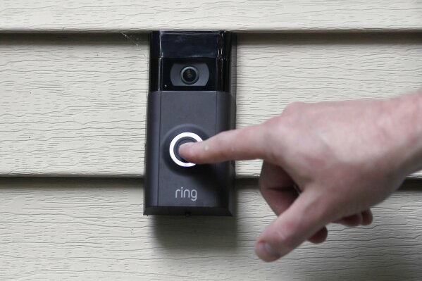 FILE - In this Tuesday, July 16, 2019, file photo, Ernie Field pushes the doorbell on his Ring doorbell camera at his home in Wolcott, Conn. Amazon-owned doorbell camera company Ring is facing questions from a U.S. senator over its partnerships with police departments around the country. Sen. Edward Markey, a Massachusetts Democrat, sent a letter Thursday to Amazon CEO Jeff Bezos raising privacy and civil liberty concerns about Ring cameras that are capturing and storing footage of U.S. neighborhoods.(AP Photo/Jessica Hill, File)