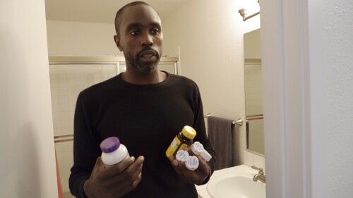 Anthony Jones takes his daily lupus medication and supplements at his Seattle apartment on June 20, 2023. Diagnosed with the disease when he was 19, Jones sometimes has difficulty making it to work when his lupus flares up. Washington lawmakers had cases like his in mind when they passed a new long-term care tax that takes effect July 1, making Washington the first state in the nation to deduct money from workers' paychecks to finance long-term care benefits. (AP Photo/Ed Komenda)