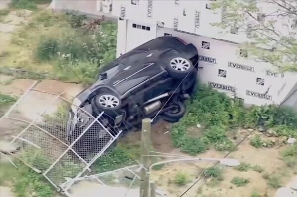In an image taken from video shows aerial footage of a crashed vehicle that was part of a police pursuit, Wednesday, May 15 ,2024, in Chester, Pa. A pursuit through two states that involved two separate shootouts with law enforcement officers and several crashes ended with the death of the woman being sought, authorities said. (WPVI-TV/6ABC via AP)