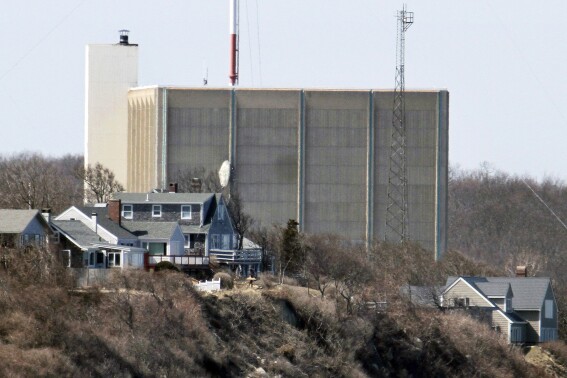 FILE - A portion of the Pilgrim Nuclear Power Station is visible beyond houses along the coast of Cape Cod Bay in Plymouth, Mass., March 30, 2011. Massachusetts environmental regulators have denied a request Monday, July 24, 2023, by the company dismantling a shuttered nuclear power plant to release more than 1 million gallons of radioactive wastewater into Cape Cod Bay. (AP Photo/Steven Senne, File)