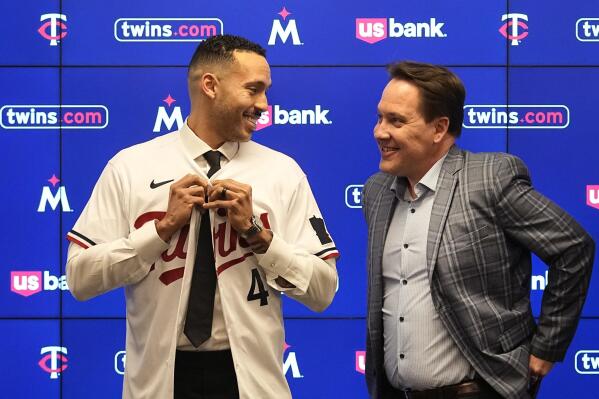 Minnesota Twins' Carlos Correa, left, puts on a team jersey alongside Twins president of baseball operations Derek Falvey at Target Field Wednesday, Jan. 11, 2023, in Minneapolis. The team and Correa agreed to a six-year, $200 million contract. (AP Photo/Abbie Parr)