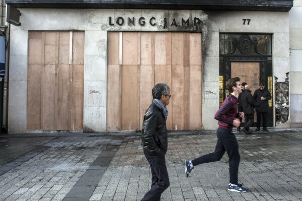 
              Outside view of a store vandalized and set on fire the day after riots erupted on the Champs Elysees during the 18th straight weekend of demonstrations by the yellow vests in Paris, France, Sunday, March 17, 2019. Paris cleaned up one of the world's most glamorous avenues Saturday after resurgent rioting by yellow vest protesters angry at President Emmanuel Macron stunned the nation. (AP Photo/Rafael Yaghobzadeh)
            