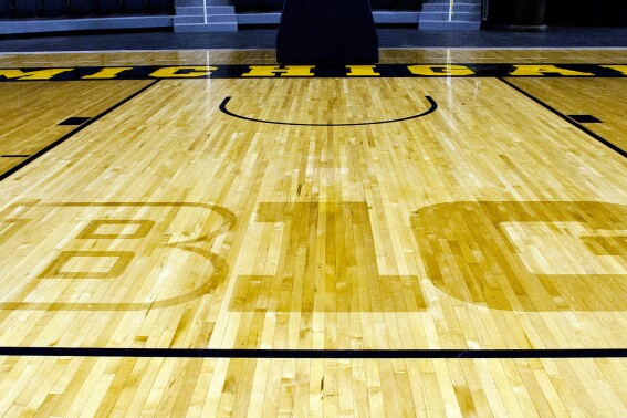 FILE - In this Oct. 11, 2011, file photo, the new Big Ten Conference logo "B1G" is stained into the wood of the newly-renovated Crisler Arena court during NCAA college basketball media day in Ann Arbor, Mich. Southern California and UCLA will play two road games apiece against the Big Ten's easternmost schools while fellow conference newcomers Oregon and Washington will make one cross-country trip each during the 2024-25 men's basketball season. (AP Photo/Tony Ding, File)