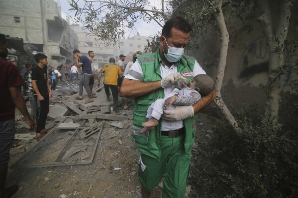 Palestinian medic takes a baby pulled out of buildings destroyed in the Israeli bombardment of the Gaza Strip in Rafah, Sunday, Oct. 22, 2023. (AP Photo/Hatem Ali)