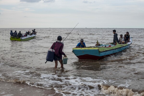 Fishermen prepare to leave on a beach in Tanah Kuning, near the site for the future development of the Kalimantan Industrial Park Indonesia, in North Kalimantan, Indonesia, Wednesday, Aug. 23, 2023. The industrial park being built in Indonesia on the tropical island of Borneo that has attracted billions of dollars in foreign and domestic investment is damaging the environment in an area where endangered species live and migrate. (AP Photo/Yusuf Wahil)