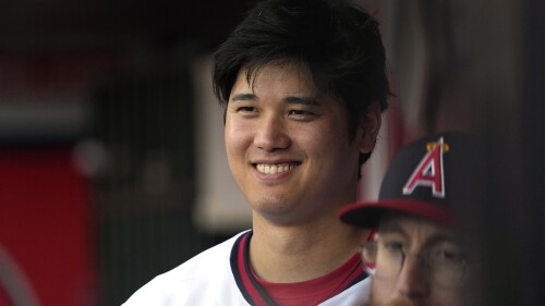 Los Angeles Angels' Shohei Ohtani smiles as he stands in the dugout prior to a baseball game against the Pittsburgh Pirates Saturday, July 22, 2023, in Anaheim, Calif. (AP Photo/Mark J. Terrill)