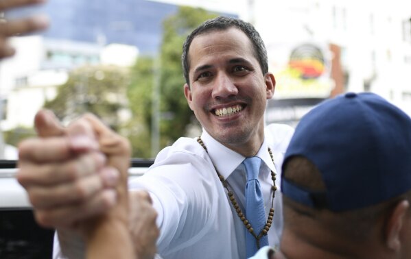 Opposition political leader Juan Guaido greets a supporter as he prepares to leave after his march was blocked by police in Caracas, Venezuela, Tuesday, March 10, 2020. Guaido called for the march aimed at retaking the National Assembly legislative building, which opposition lawmakers have been blocked from entering. (AP Photo/Matias Delacroix)