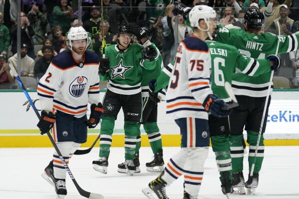 Edmonton Oilers' Duncan Keith (2) and Evan Bouchard (75) skate past as Dallas Stars' Jason Robertson, left rear, celebrates Joe Pavelski (16) and Roope Hintz, right, after scoring in the first period of an NHL hockey game in Dallas, Tuesday, Nov. 23, 2021. (AP Photo/Tony Gutierrez)