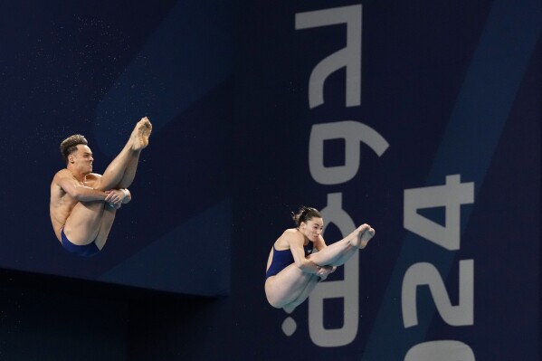 Thomas Daley and Scarlett Mew Jensen, of Great Britain, compete in the mixed synchronized diving 3 and 10m platform final at the World Aquatics Championships in Doha, Qatar, Friday, Feb. 2, 2024. (AP Photo/Hassan Ammar)