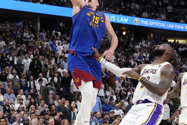 Denver Nuggets center Nikola Jokic (15) goes up to shoot against Los Angeles Lakers forward LeBron James, right, during the second half in Game 1 of an NBA basketball first-round playoff series Saturday, April 20, 2024, in Denver. (AP Photo/Jack Dempsey)