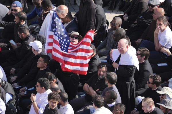 A man waves a U.S. flag as Pope Leo XIV tours St. Peter's Square on his popemobile at the Vatican prior to the inaugural Mass of his pontifcate, Sunday, May 18, 2025. (AP Photo/Jacquelyn Martin, Pool)