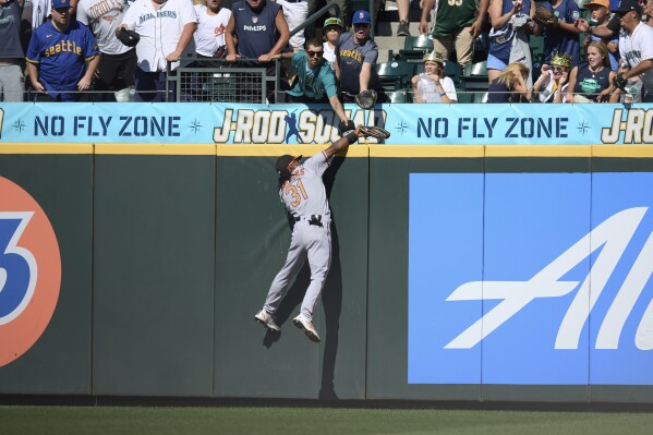 Baltimore Orioles center fielder Cedric Mullins catches a ball hit by Seattle Mariners' Ty France over the fence during the ninth inning of a baseball game, Sunday, Aug. 13, 2023, in Seattle. (AP Photo/John Froschauer)