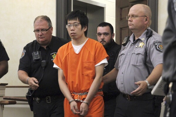 Tailei Qi, the graduate student suspected in the fatal shooting of a University of North Carolina at Chapel Hill faculty member, center, makes his first appearance at the Orange County Courthouse in Hillsborough, N.C., Tuesday, Aug. 29, 2023. Qi has been charged by the UNC Police Department with first-degree murder and possession of a weapon on educational property, both felony charges. (AP Photo/Hannah Schoenbaum)