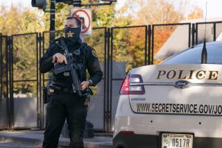 FILE - A U.S. Secret Service officer takes a position in the street as President Donald Trump's motorcade arrives at the White House after golfing at his Trump National Golf Club in Sterling, Va., in Washington, Nov. 8, 2020, a day after was defeated by President-elect Joe Biden. The National Archives has requested a probe of “the potential unauthorized deletion” of text messages the Secret Service sent and received around the attack on the U.S. Capitol on Jan. 6, 2021. (AP Photo/J. Scott Applewhite)