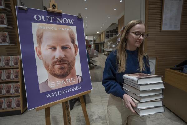A member of staff places the copies of the new book by Prince Harry called "Spare" at a book store in London, Tuesday, Jan. 10, 2023. Prince Harry's memoir "Spare" went on sale in bookstores on Tuesday, providing a varied portrait of the Duke of Sussex and the royal family. (AP Photo/Kin Cheung)