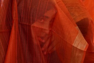 A Kashmiri Muslim bride looks through her veil during a mass wedding in Srinagar, Indian controlled Kashmir, Thursday, June 15, 2023. Mass weddings in India are organized by social organizations primarily to help economically backward families who cannot afford the high ceremony costs as well as the customary dowry and expensive gifts that are still prevalent in many communities. (AP Photo/Mukhtar Khan)