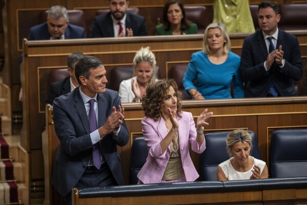 From left to right: Spain's Socialist Prime Minister Pedro Sanchez, Spain's Deputy Prime Minister and Ministry of Finance Maria Jesus Montero and Spain's second Deputy Prime Minister and Labour Minister Yolanda Diaz applaud after the approval to an amnesty law at the Spanish parliament's lower house in Madrid on Thursday, May 30, 2024. Spain's Parliament has given final approval to a controversial amnesty law for hundreds of Catalan separatists involved in the illegal and unsuccessful 2017 secession bid. The legislation was backed in the lower house by Spain's left-wing coalition government, two Catalan separatist parties, and other smaller parties. It passed despite the conservative Popular Party and far-right Vox voting against it. (AP Photo/Bernat Armangue)