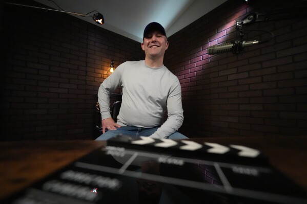 Joe Seales, owner of Right Side Broadcasting Network, sits for a portrait in a studio in Opelika, Ala., on Saturday, March 2, 2024. Seales and his wife, a former Navy physician's assistant who co-owns RSBN, started small, with a single camera at a Trump rally in Phoenix. Over the years, they turned a shoestring operation into one with 10 full-time employees and a house full of sophisticated computer and video gear. (AP Photo/Mike Stewart)