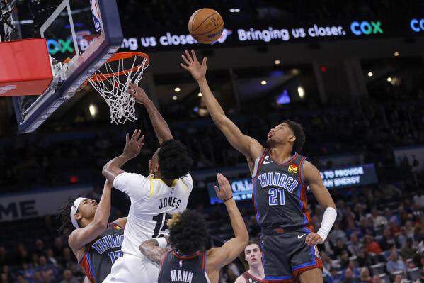 Oklahoma City Thunder guard Aaron Wiggins (21) grabs a rebound near, from left to right, Thunder forward Ousmane Dieng, Utah Jazz center Damian Jones and Thunder guard Tre Mann during the second half of an NBA basketball game Friday, March, 3, 2023, in Oklahoma City. (AP Photo/Nate Billings)