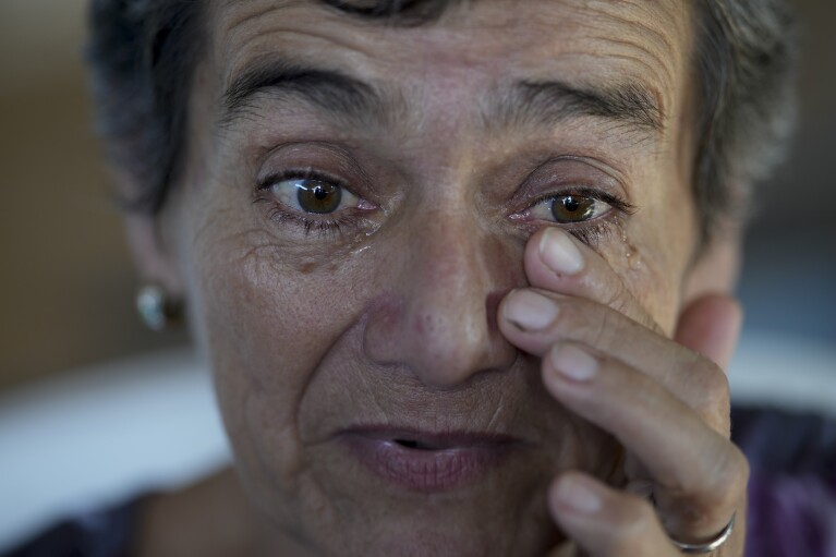 Geronima Benitez wipes her eyes as she speaks about her son Victor Emanuel, 17, who was murdered by drug traffickers who were never arrested two years ago, during an interview at her home in Rosario, Argentina, Tuesday, April 9, 2024. Benítez said her son’s killer still lives down her street and is not convinced a prison sentence would make a difference. “We, on the outside, live in prison,” she said. “Those inside have everything.” (AP Photo/Natacha Pisarenko)