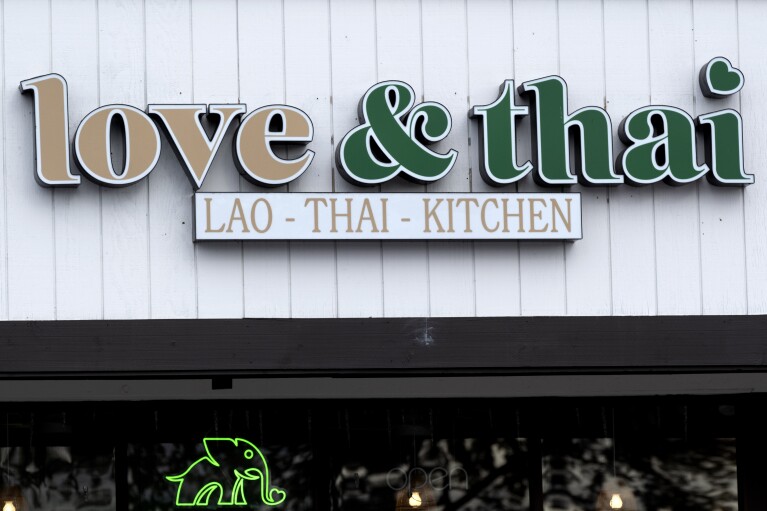 The "Love & Thai" name is seen above David Rasavong's new restaurant in Fresno, Calif. on Wednesday, Dec. 20, 2023. Rasavong is back in operation after being wrongfully accused of abusing a dog to turn it into meat. It may be astonishing to some that a claim rooted in a racist stereotype took down the restaurant three years after "Stop Asian Hate" became a rallying cry. (AP Photo/Richard Vogel)