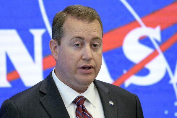 FILE - In this photo provided by NASA, NASA Chief Financial Officer Jeff DeWit speaks during a news conference in New York on June 7, 2019. Arizona Republican Party Chairman Jeff DeWit has resigned after he could be heard in a leaked recording offering a job and asking U.S. Senate candidate Kari Lake to name a price that would keep her out of politics. (Bill Ingalls/NASA via AP, File)
