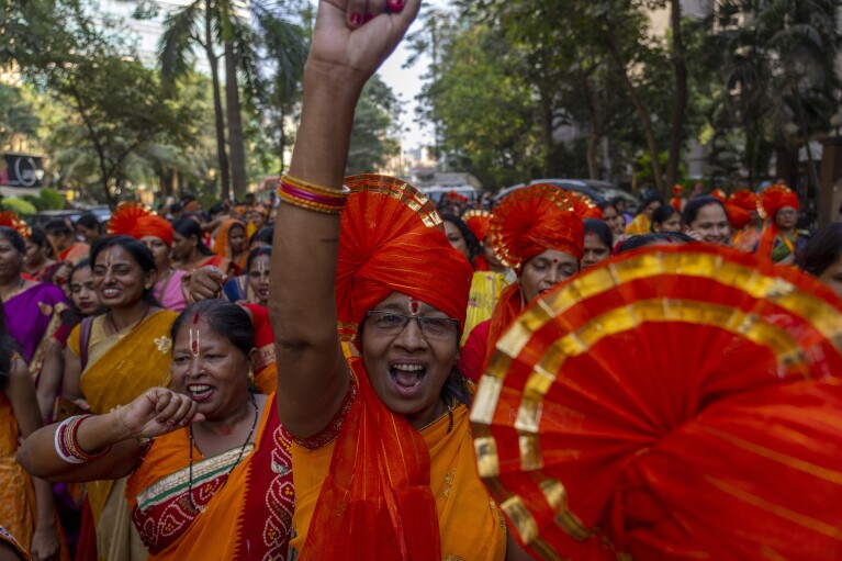रविवार, 21 जनवरी, 2024 को मुंबई, भारत में एक जुलूस के दौरान भारत के उत्तरी अयोध्या शहर में भगवान राम के लिए एक भव्य मंदिर के उद्घाटन का जश्न मनाने के लिए हिंदू महिलाएं पवित्र नारे लगाती हैं। (एपी फोटो/रफीक मकबूल)
