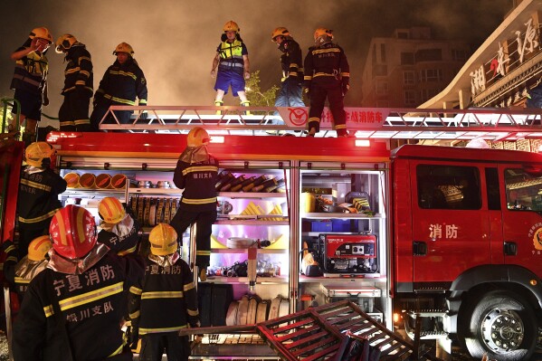 In this photo released by Xinhua News Agency, firefighters work at the site of an explosion at a restaurant in Yinchuan, northwest China's Ningxia Hui Autonomous Region Wednesday, June 21, 2023. Cooking gas caused a massive explosion at a barbecue restaurant in northwestern China killed dozens and injured some, Chinese authorities said Thursday. (Wang Peng/Xinhua via AP)