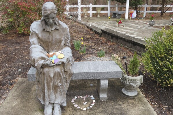 FILE - A sculpture of a grieving mother sits a memorial garden in Toms River, N.J. Feb. 21, 2023, for children who died from any cause. Toms River and an environmental group on Oct. 4, 2023, sued to overturn a settlement New Jersey reached with the site's current owner, BASF Corp. to restore environmental conditions there, calling the deal inadequate. (AP Photo/Wayne Parry, File)