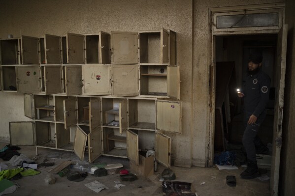 A police officer from Idlib shows a room of a damaged police station in the Bab Touma neighborhood of the Old City of Damascus, Syria, Saturday, Dec. 14, 2024. (AP Photo/Leo Correa)