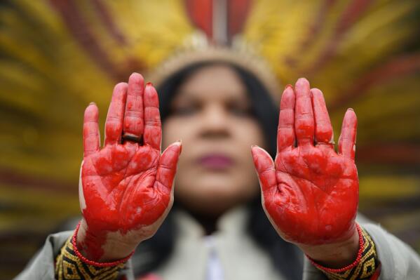 Indigenous leader Sonia Guajajara from the Guajajara ethnic group shows her hands painted in red symbolizing bloodshed, during a protest against violence, illegal logging, mining and ranching, and to demand government protection for their reserves, one day before the celebration of "Amazon Day," in Sao Paulo, Brazil, Sunday, Sept. 4, 2022. (AP Photo/Andre Penner)