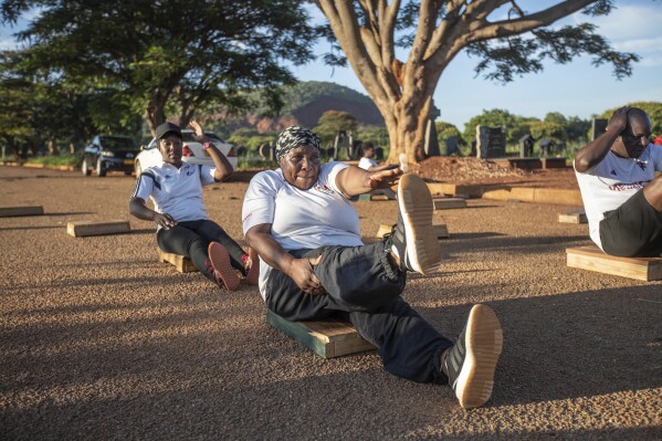 Susan Gomo, 65, exercises with the Commandos Fitness Club at the Warren Hills cemetery in Harare, Zimbabwe, Saturday, Jan. 18, 2025. ( AP Photo/Aaron Ufumeli)