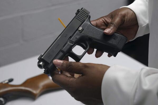 FILE - A handgun from a collection of illegal guns is reviewed during a gun buyback event in Brooklyn, N.Y., May 22, 2021. The Supreme Court, Thursday, June 23, 2022, struck down a restrictive New York gun law in a major ruling for gun rights. (AP Photo/Bebeto Matthews, FIle)