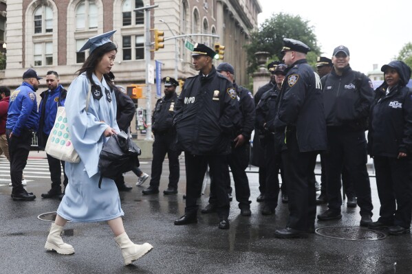 Alumni will pass police lines across the street from the main gate of Columbia University in New York on Wednesday, May 21, 2025. (AP Photo/Heather Khalifa)