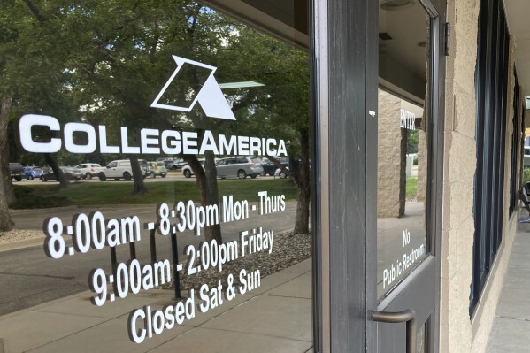 A CollegeAmerica sign is displayed on a window outside their location in Fort Collins, Colo., Tuesday, July 25, 2023. Federal and Colorado officials announced Tuesday that Colorado students who attended the career school, which lost accreditation and closed in 2021, will have their federal student loans refunded and remaining balances forgiven. (AP Photo/Mead Gruver)