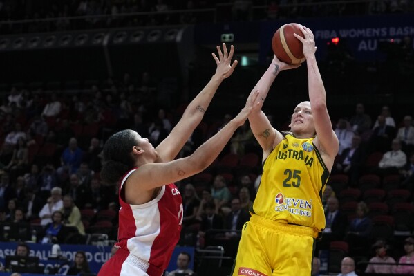 FILE - Australia's Lauren Jackson shoots over Canada's Natalie Achonwa during the bronze medal game at the women's Basketball World Cup in Sydney on Oct. 1, 2022. Jackson is coming out of retirement again in a bid to make the Australian team and compete at a fifth Olympics. The 42-year-old, three-time WNBA MVP was included in Australia’s 26-player squad Wednesday, March 27, and is widely tipped to make the final 12 for the Opals at the Olympics. (AP Photo/Rick Rycroft, File)