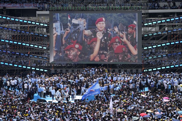 Genç başkan adayı Prabowo Subianto'nun orduda görev yaparken çekilmiş bir fotoğrafı, 10 Şubat 2024 Cumartesi günü Endonezya'nın Jakarta kentindeki Gelora Bung Karno ana stadyumunda düzenlenen kampanya mitingi sırasında büyük bir video ekranında gösteriliyor. Savunma Bakanı Subianto, bir ile bağları olan zengin eski general... Giden Endonezya başkanı ve onun diktatörlük geçmişi, resmi olmayan istatistiklerin ilk tur oylamada açık bir çoğunluk elde ettiğini göstermesinin ardından, onun bir sonraki başkanı olacak.  (AP Fotoğrafı/Dita Alangkara, Dosya)