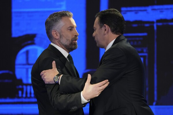 FILE - Socialist Party leader Pedro Nuno Santos, left, and Luis Montenegro, leader of the Social Democratic Party, greet each other before an election TV debate in Lisbon, Portugal, Feb. 19, 2024. The center-left Socialist Party and center-right Social Democratic Party have alternated in power for decades. But they are unsure of how much support they might need from smaller rival parties to form a government after the March 10 vote. (AP Photo/Armando Franca, File)