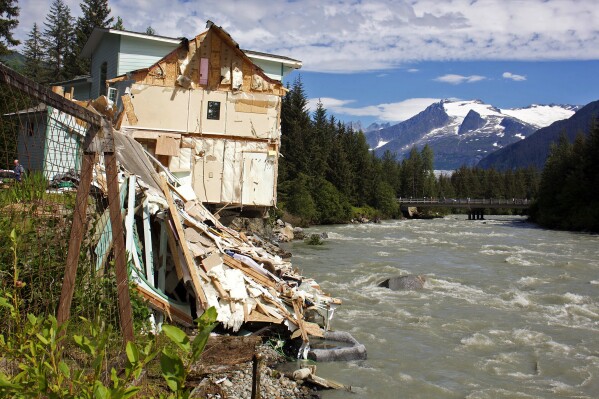 Debris from a home that partially fell into the Mendenhall River sits on its banks in Juneau, Alaska, on Sunday Aug. 6, 2023. The city of Juneau says the Mendenhall River flooded on Saturday because of a major release from Suicide Basin above Alaska's capital city, and at least two buildings were destroyed. (Mark Sabbatini/Juneau Empire via AP)