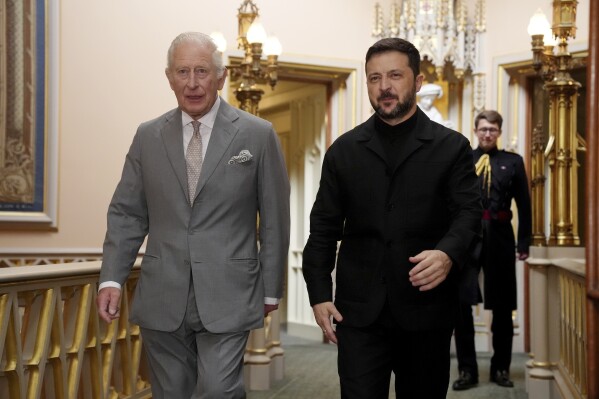 Britain's King Charles III, left, walks with Ukrainian President Volodymyr Zelenskyy on the occasion of their private audience at Windsor Castle, England, Monday, June 23, 2025. (Jonathan Brady/Pool Photo via AP)