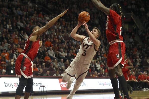 Virginia Tech's Sean Pedulla (3) center, attempts a shot while defended by North Carolina State's Casey Morsell, left, and Greg Gantt during the second half of an NCAA college basketball game Saturday, Jan. 7, 2023, in Blacksburg, Va. (Matt Gentry/The Roanoke Times via AP)