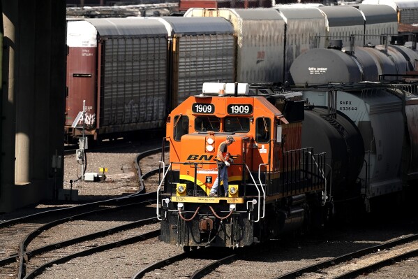 FILE - A worker boards a locomotive at a BNSF rail yard Wednesday, Sept. 14, 2022, in Kansas City, Kan. Kansas became the tenth state in the nation Wednesday, Oct. 11, 2023, to require two-person railroad crews over the objections of the freight railroads, but the industry may challenge the rule in court as it has in other states like Ohio. (AP Photo/Charlie Riedel, File)