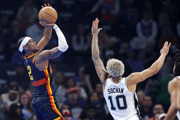 Oklahoma City guard Shai Gilgeous-Alexander (2) shoots over San Antonio forward Jeremy Sochan (10) during the first half of an NBA in-season tournament basketball game Tuesday, Nov. 14, 2023, in Oklahoma City. (AP Photo/Nate Billings)