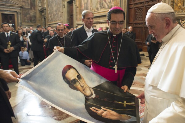 Pope Francis is presented with an image of Roman Catholic Archbishop Oscar Romero during a private audience granted to participants to the pilgrimage from El Salvador at the Vatican, Tuesday, Oct. 20, 2015. (L'Osservatore Romano/Pool Photo via AP, file)
