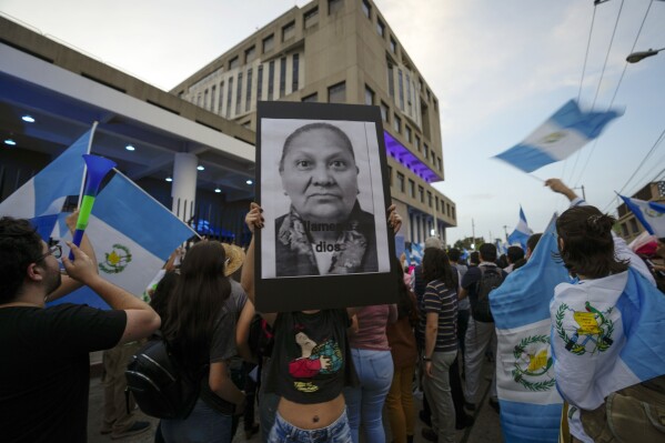 A demonstrator holds up a protest poster of Attorney General Consuelo Porras outside her office during a rally in support of the electoral process in Guatemala City, July 14, 2023. (AP Photo/Moises Castillo, File)