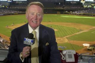 FILE - Los Angeles Dodgers television play-by-play announcer Vin Scully rehearses before a baseball game between the Dodgers and the Arizona Diamondbacks in Phoenix on July 3, 2002. Scully, whose dulcet tones provided the soundtrack of summer while entertaining and informing Dodgers fans in Brooklyn and Los Angeles for 67 years, died Tuesday night, Aug. 2, 2022, the team said. He was 94. (AP Photo/Paul Connors, File)