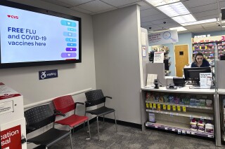 FILE - A sign for flu vaccination is displayed on a screen at a pharmacy store in Buffalo Grove, Ill., Tuesday, Feb. 13, 2024. Early estimates suggest flu shots are performing OK in the current U.S. winter flu season. The vaccines were around 40% effective in preventing adults from getting sick enough from the flu that they had to go to a doctor’s office, clinic or hospital, health officials said during a Centers for Disease Control and Prevention vaccines meeting Wednesday, Feb. 28, 2024. (AP Photo/Nam Y. Huh, File)