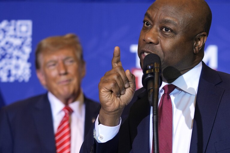 Sen. Tim Scott, R-S.C., speaks as Republican presidential candidate former President Donald Trump listens at a campaign event in Concord, N.H., Friday, Jan. 19, 2024. (AP Photo/Matt Rourke)