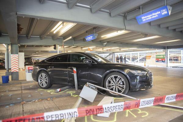 A damaged car is parked in parking lot 2 at Cologne/Bonn Airport Friday, March 24, 2023. A man drove straight at people, but most were able to avoid him. Police said the injuries to some of the pedestrians on Friday were considered minor. The man also allegedly hit several cars. Dpa says a 57-year-old driver was detained and taken to the hospital. Two police officers received slight injuries when the suspect allegedly resisted arrest. (Henning Kaiser/dpa via AP)